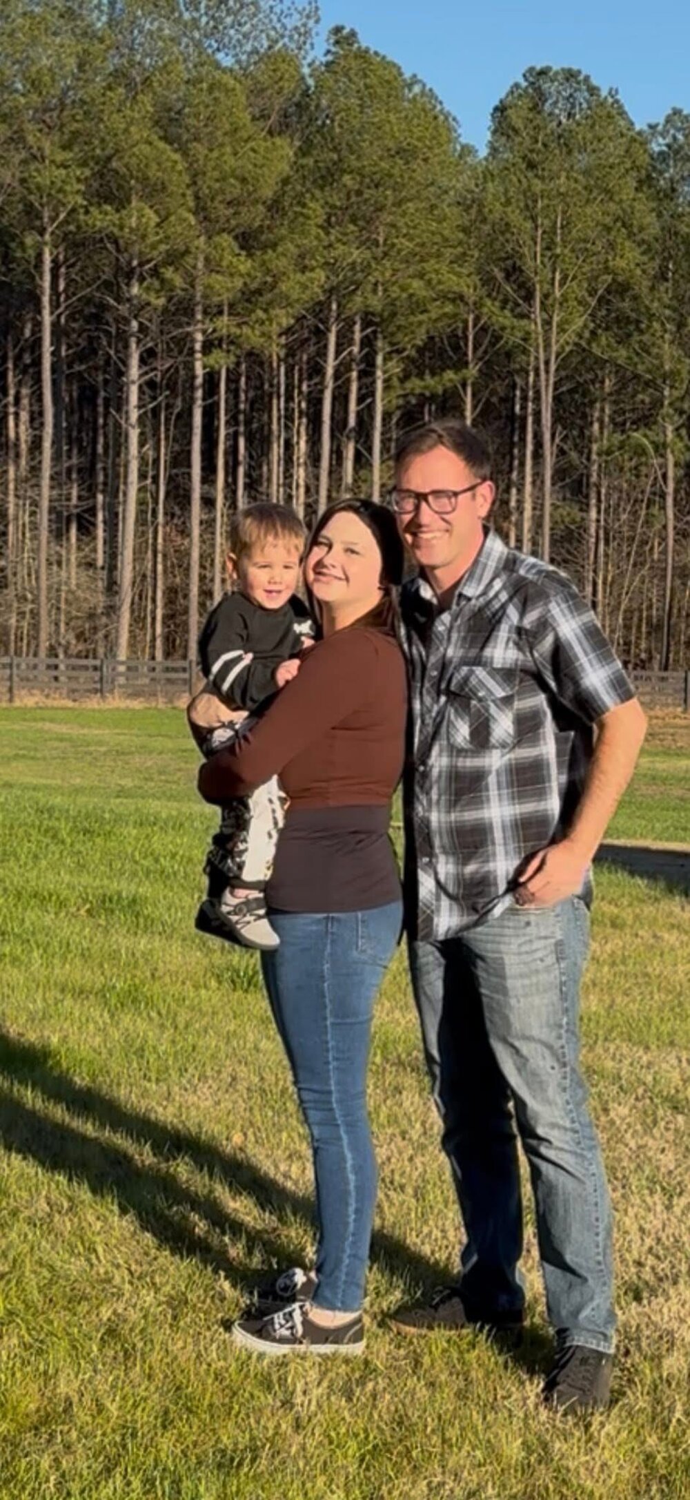 Billi with her husband and son on their farm